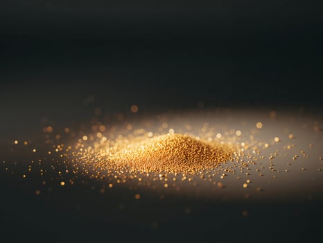 Golden Beads Pile on a Dark Surface, Elegant and Luxurious Visual Composition photo