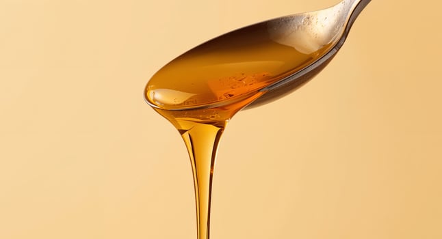 Golden Cascade. Honey Dripping from a Spoon in a Warm, Inviting Composition. photo