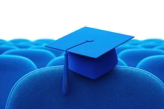 A bright blue graduation cap is placed on the back of a blue chair amidst an arrangement of empty seats, indicating preparation for an upcoming graduation ceremony. The scene is bright and minimalist. photo