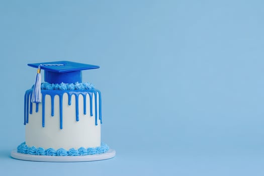 A decorated cake in shades of blue features dripping icing and a graduation cap with a tassel. This festive dessert symbolizes achievement and celebration, perfect for graduation events. photo