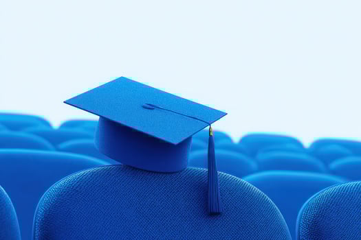 A bright blue graduation cap sits atop a blue chair, awaiting a ceremony in a spacious auditorium. The chairs are arranged in neat rows, creating an atmosphere of anticipation and celebration. photo