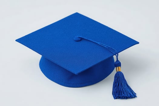 A vibrant blue graduation cap rests on a plain background, symbolizing academic success. The cap features a gold tassel, indicating a special milestone in education. Perfect for graduation events. photo