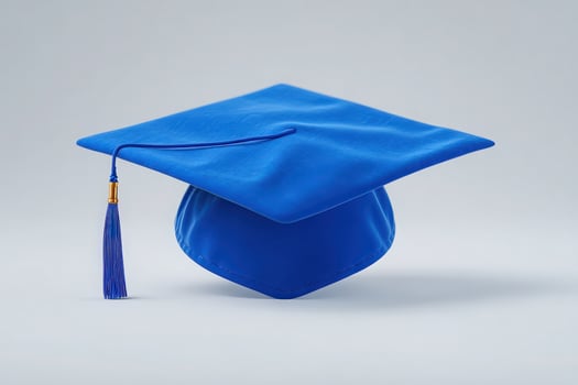 A vibrant blue graduation cap rests against a plain background. The cap features a traditional tassel, representing achievement. The design highlights the significance of educational milestones. photo