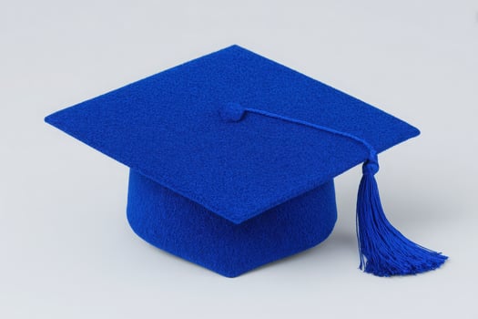 A bright blue graduation cap rests on a flat surface, showcasing its unique color and design. The cap is adorned with a long tassel, representing academic success and readiness for future challenges. photo