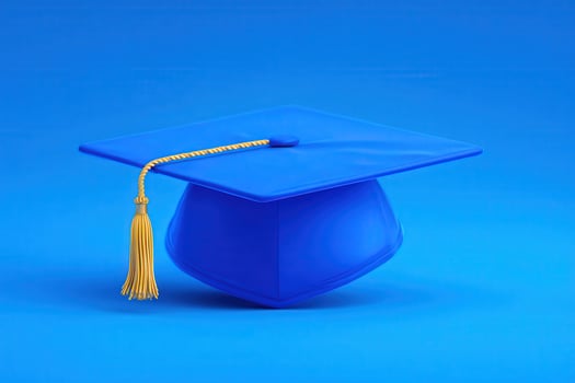A bright blue graduation cap is centered against a matching blue background. The cap features a yellow tassel, symbolizing achievement and celebration of education milestones. photo