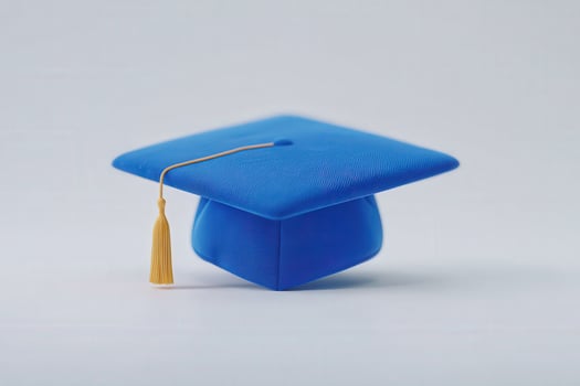A blue graduation cap rests on a plain, neutral surface, showcasing a vibrant golden tassel. This image represents achievement and educational milestones, perfect for celebrating graduations. photo