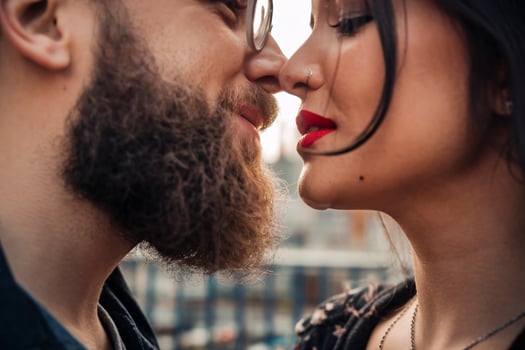 Intimate moment between a man and woman, showcasing affection and connection against a soft background. photo