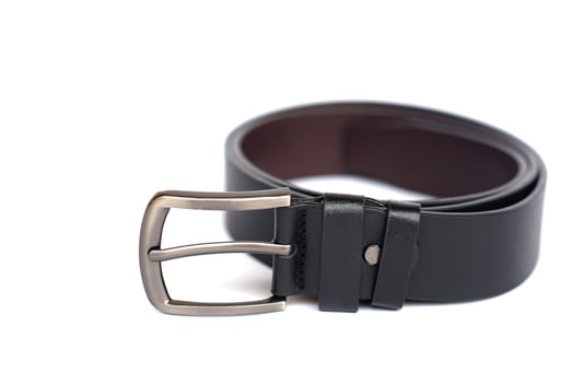 Close-up of a stylish black leather men belt with metallic buckle on white background. Fashion accessory for formal and casual wear, symbol of style, durability, and essential men wardrobe item. photo