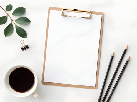 Blank Clipboard with Pencils Coffee and Leaves on White Marble Desk photo