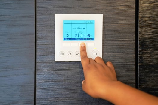 Hand woman turns on air conditioning. photo