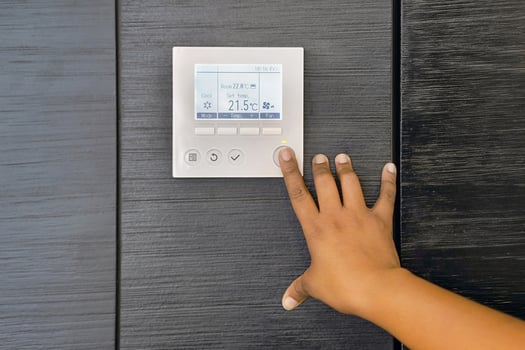 hand of black woman turns on air conditioning in home photo