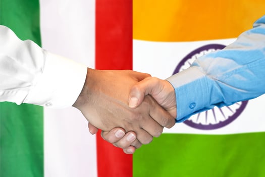 handshake on Italy and India flag background. photo