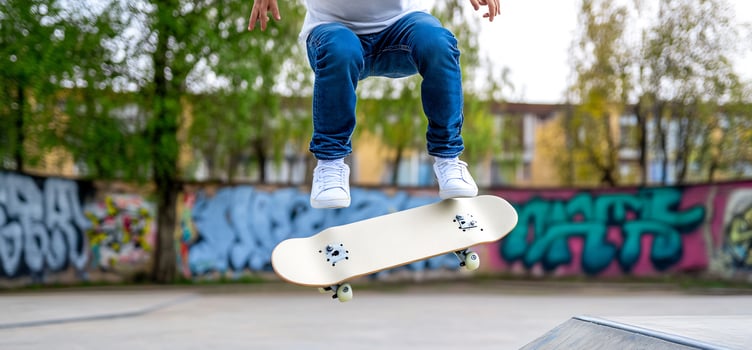 Skateboarder midair ollie, graffiti park photo