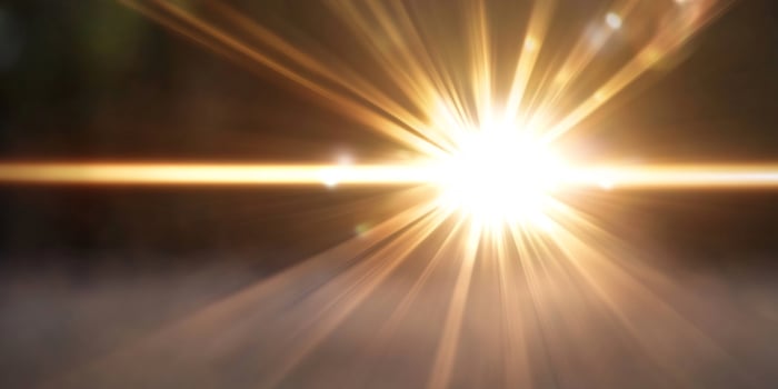 Bright sun rays burst through clouds. Background design photo