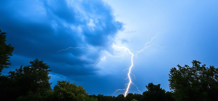 Lightning storm over trees at dusk. Nature background photo