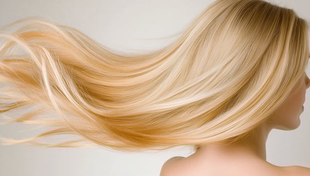 Womans long blonde hair flowing, studio shot photo