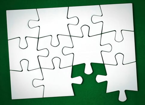 A piece of white puzzle on a green background photo