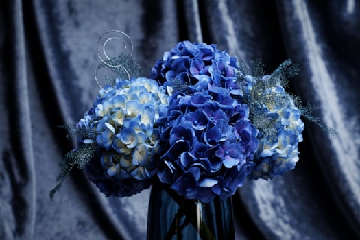 A blue vase with blue flowers in it photo