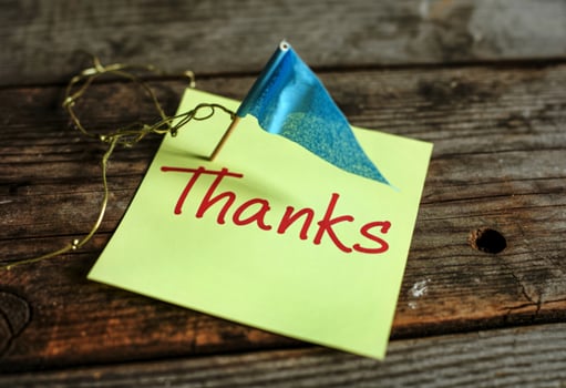 Thank you note on a wooden table with a flag photo