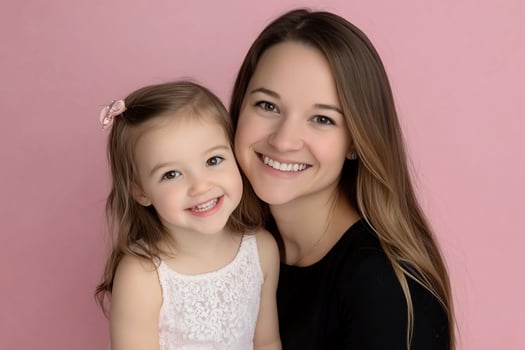 Happy mother and daughter portrait, pink background, family love, studio shot photo