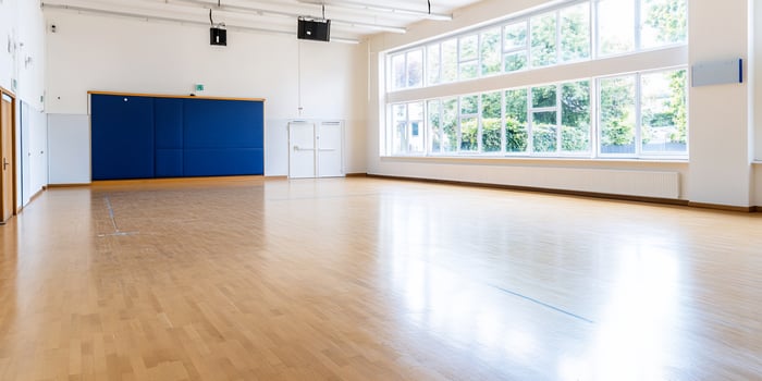 Empty bright hall, wooden floor, large window, trees outside, event space photo