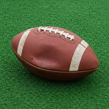 Worn Leather Football on Green Turf A Photorealistic Sports Image. photo