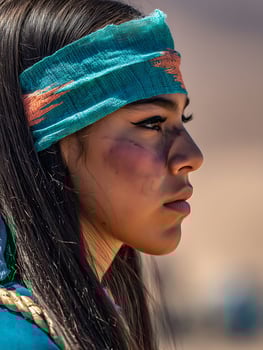 Close up portrait of a young woman with long dark hair wearing a teal headband, showcasing cultural attire and makeup. photo