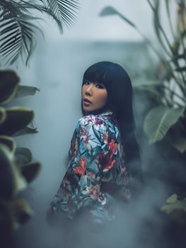 Serene Woman in Floral Kimono Amidst Lush Greenery. A captivating portrait showcasing tranquility and natural beauty. photo
