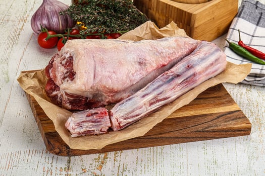 A raw meat on a cutting board with vegetables photo