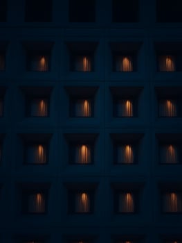 Illuminated Windows of a Modern Building at Night. A grid of windows with warm interior lighting visible through sheer curtains. photo