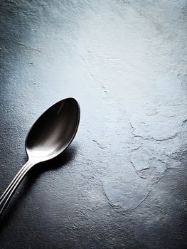 Elegant Silver Spoon on Dark Textured Surface A Close Up Still Life Image. photo
