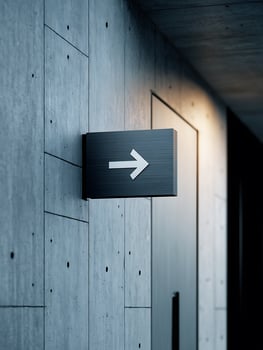 Modern Directional Sign on Concrete Wall, Architectural Detail. photo