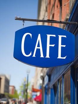 Blue Cafe Sign Hanging Outside on a Sunny Day. A close up image of a cafe sign. photo