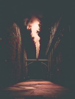 Steam Rising in a Dark City Alleyway at Night. An atmospheric image of an industrial scene. photo