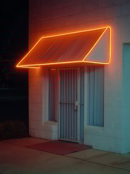 Illuminated Entrance Nighttime view of a building with an orange neon awning. photo