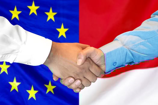 handshake on European Union and Monaco flag background. photo