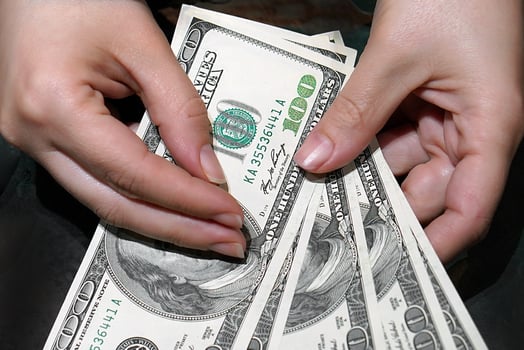 Woman hands hold and counting US dollars banknotes isolated on black background. photo