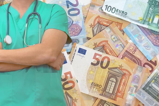 Male surgeon or doctor with stethoscope on the background of the stack of money euro bills photo