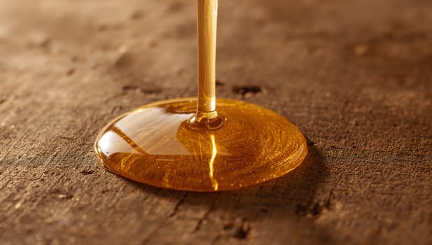 Honey dripping on wooden surface photo