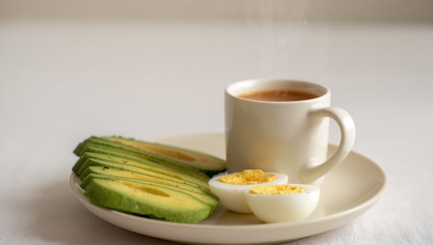 Avocado, eggs, and coffee on a plate photo