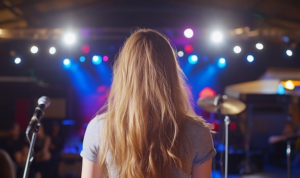 Woman facing stage, concert lights, audience, music performance photo