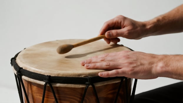 A Moment of Rhythm - Hands and Mallet Poised Over a Natural Skin Drum photo