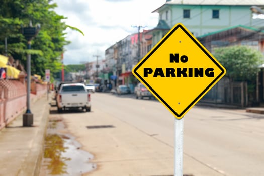 Yellow Road Sign Saying No Parking on Blurred Street photo
