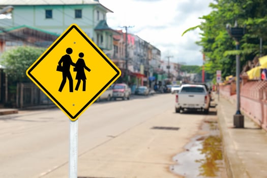 Yellow Pedestrian School Crossing Sign with Blurred Street photo