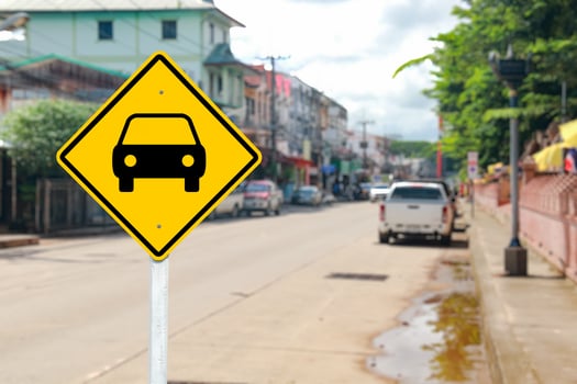 Yellow Road Sign with Car Symbol on Blurred Street photo