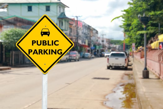 Yellow Public Parking Sign on Blurred Community Road photo