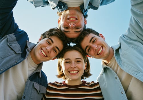 A diverse group of young friends smiles and laughs together in a circle photo