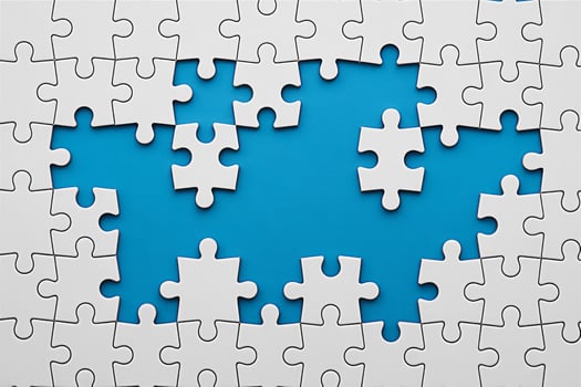 White jigsaw puzzle pieces on a blue background representing problem solving and teamwork concept photo