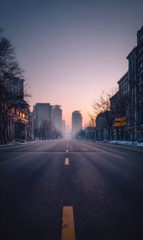 Urban city street view at sunrise with modern architecture buildings and yellow road markings a serene cityscape with a pastel sky and a road receding into the distant skyline photo
