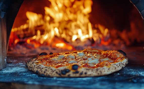 Delicious Pizza Baking in a Wood-Fired Oven With Flames and Glowing Embers photo
